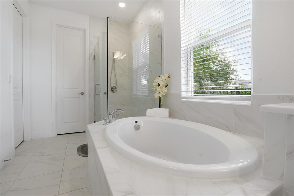 34068 Castaway Loop Wesley Chapel, FL 33543 - Photo 25 of 65 a white bath tub sitting in a spacious bathroom next to a window