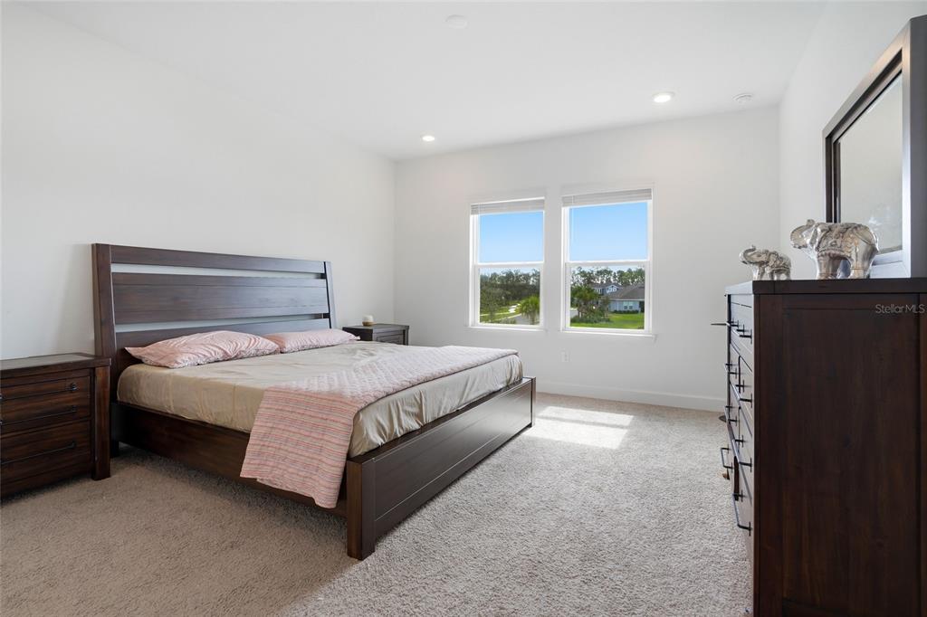 34068 Castaway Loop Wesley Chapel, FL 33543 - Photo 36 of 65 a large bed sitting in a room next to a window