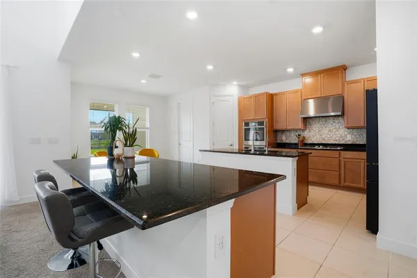 a kitchen with stainless steel appliances granite countertop a sink a stove and cabinets