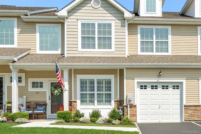 a front view of a house with a yard and potted plants