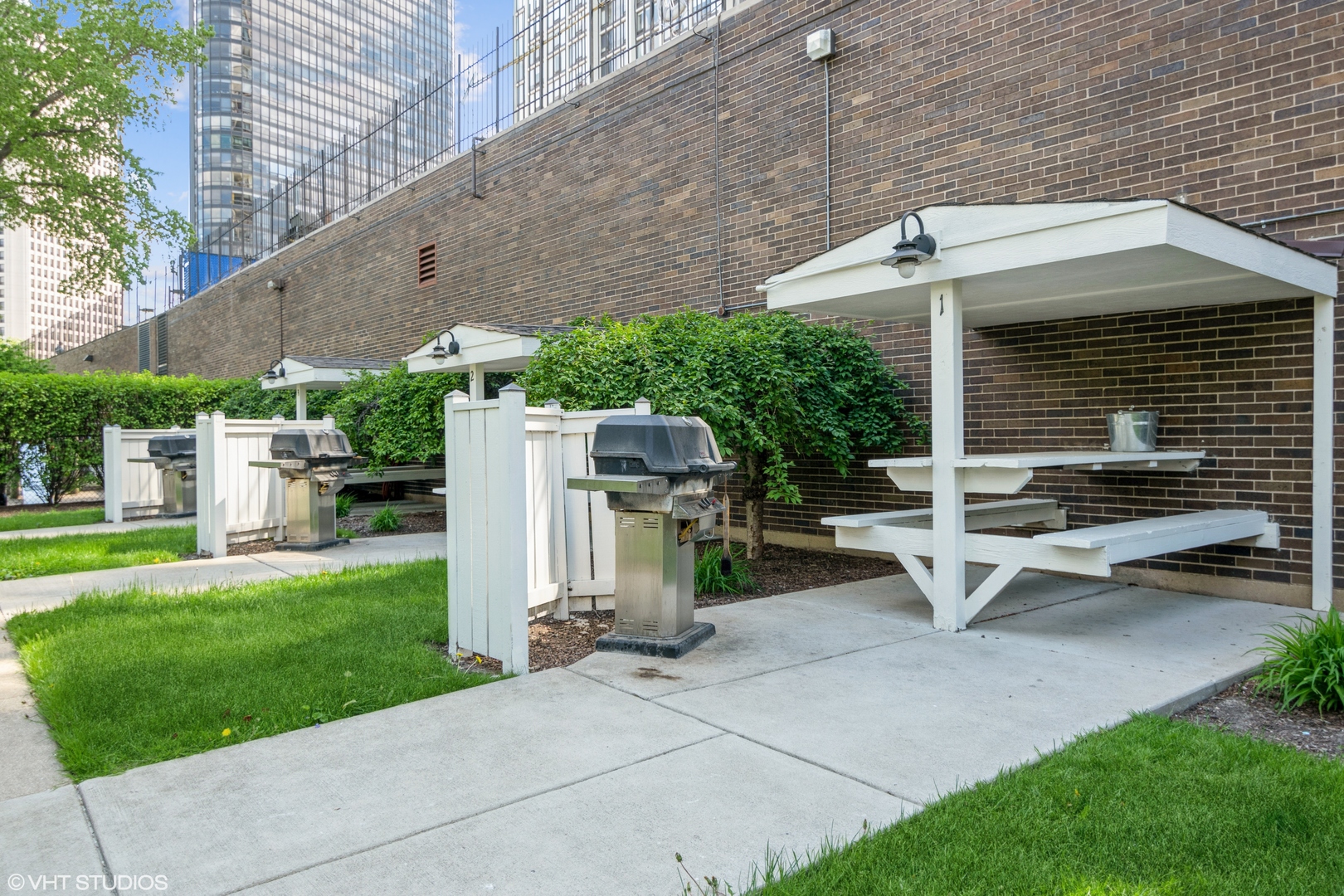 5455 North Sheridan Road, Unit 2403 Chicago, IL 60640 - Photo 15 of 20 a view of a patio with table and chairs with wooden fence and plants