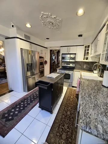 a kitchen with stainless steel appliances granite countertop a refrigerator and a stove