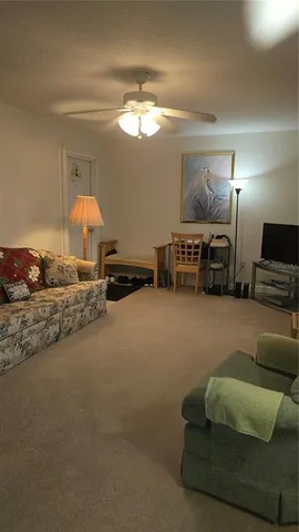 a living room with furniture a window and a lamp