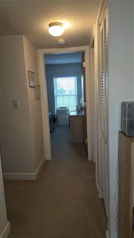 a view of a hallway with furniture and a window