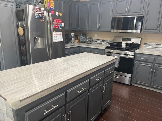 42107 Quail Run Way Lancaster, CA 93536 - Photo 11 of 38 a kitchen with granite countertop a refrigerator stove and sink