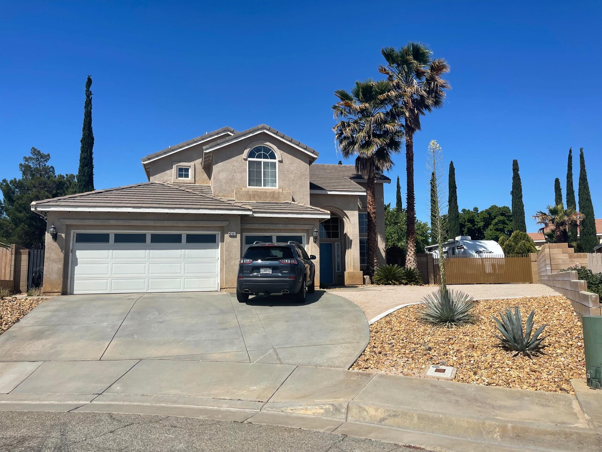 42107 Quail Run Way Lancaster, CA 93536 - Photo 2 of 38 a front view of a house with a yard