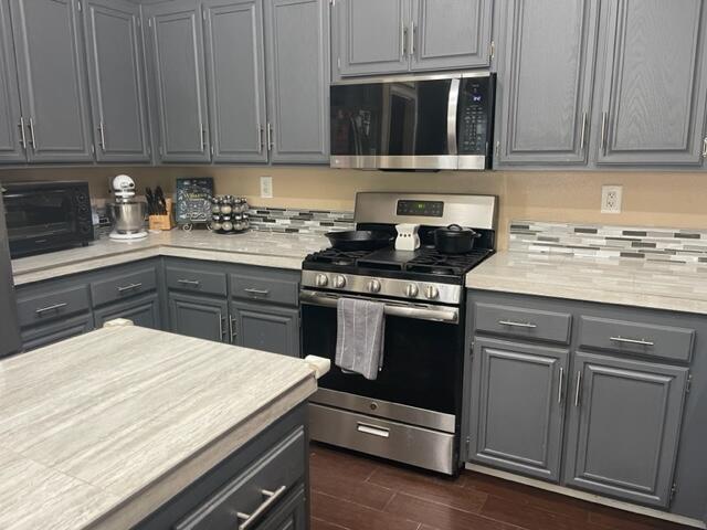42107 Quail Run Way Lancaster, CA 93536 - Photo 9 of 38 a kitchen with a stove and white cabinets