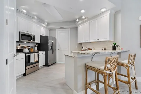a kitchen that has a lot of cabinets in it and appliances