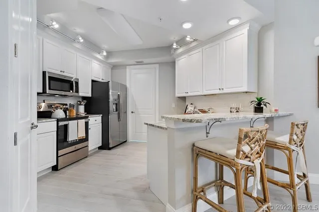 a kitchen that has a lot of cabinets in it and appliances