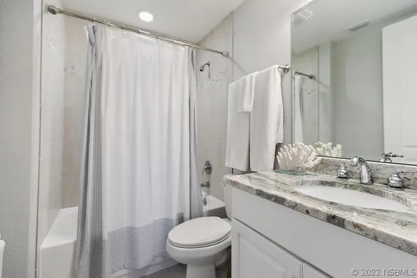 a bathroom with a granite countertop sink toilet and a mirror