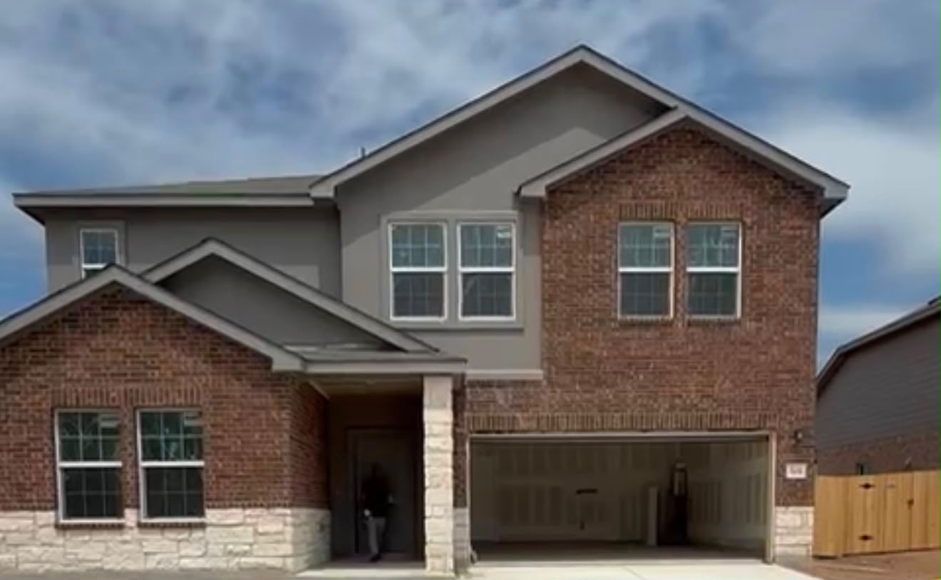 192 Rodney Boat Road Kyle, TX 78640 - Photo 1 of 38 A striking modern home with brick and stone accents, featuring an inviting covered entry and attached garage.