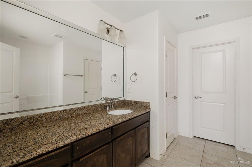 2302 North 26th Street Hidalgo, TX 78557 - Photo 7 of 19 a bathroom with a granite countertop sink and a mirror