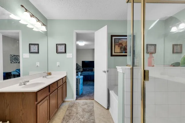 a bathroom with a double vanity sink mirror and shower