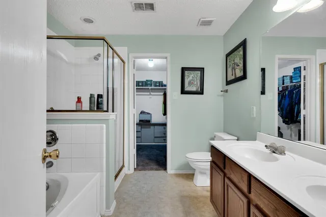a bathroom with a bathtub sink mirror vanity and toilet