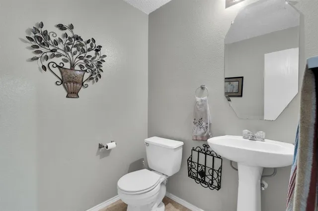 a bathroom with a toilet a sink and mirror