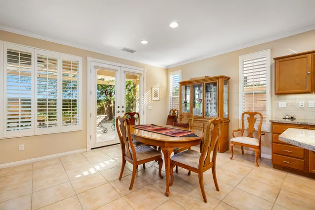 a dining hall with stainless steel appliances granite countertop a stove a sink a refrigerator and island with wooden floor