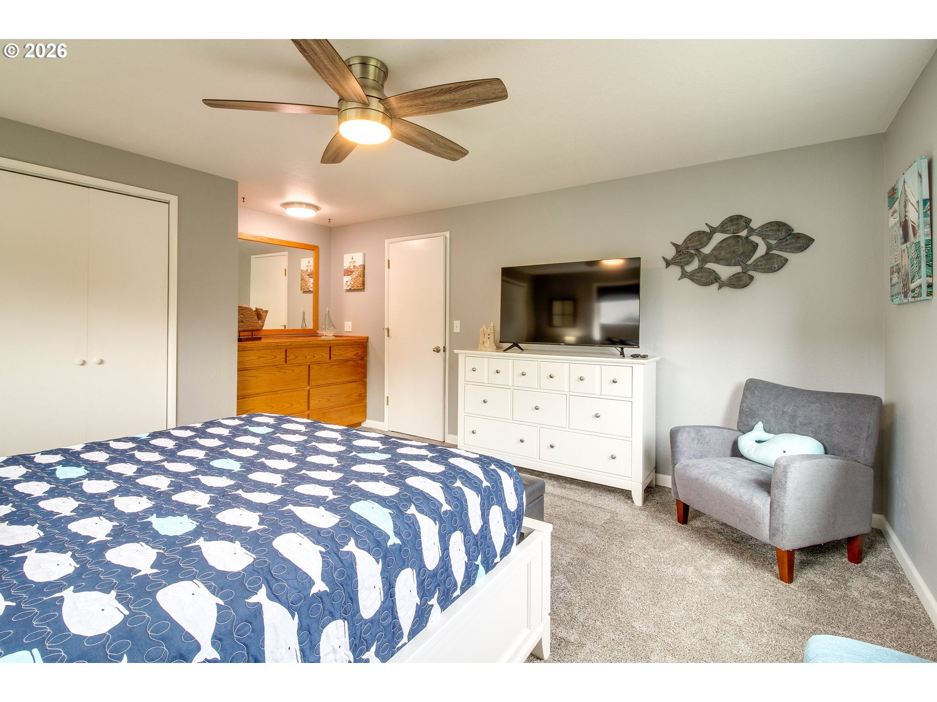 3085 Beach Loop Drive Southwest Bandon, OR 97411 - Photo 24 of 46 a spacious bedroom with a bed a couch and a flat screen tv