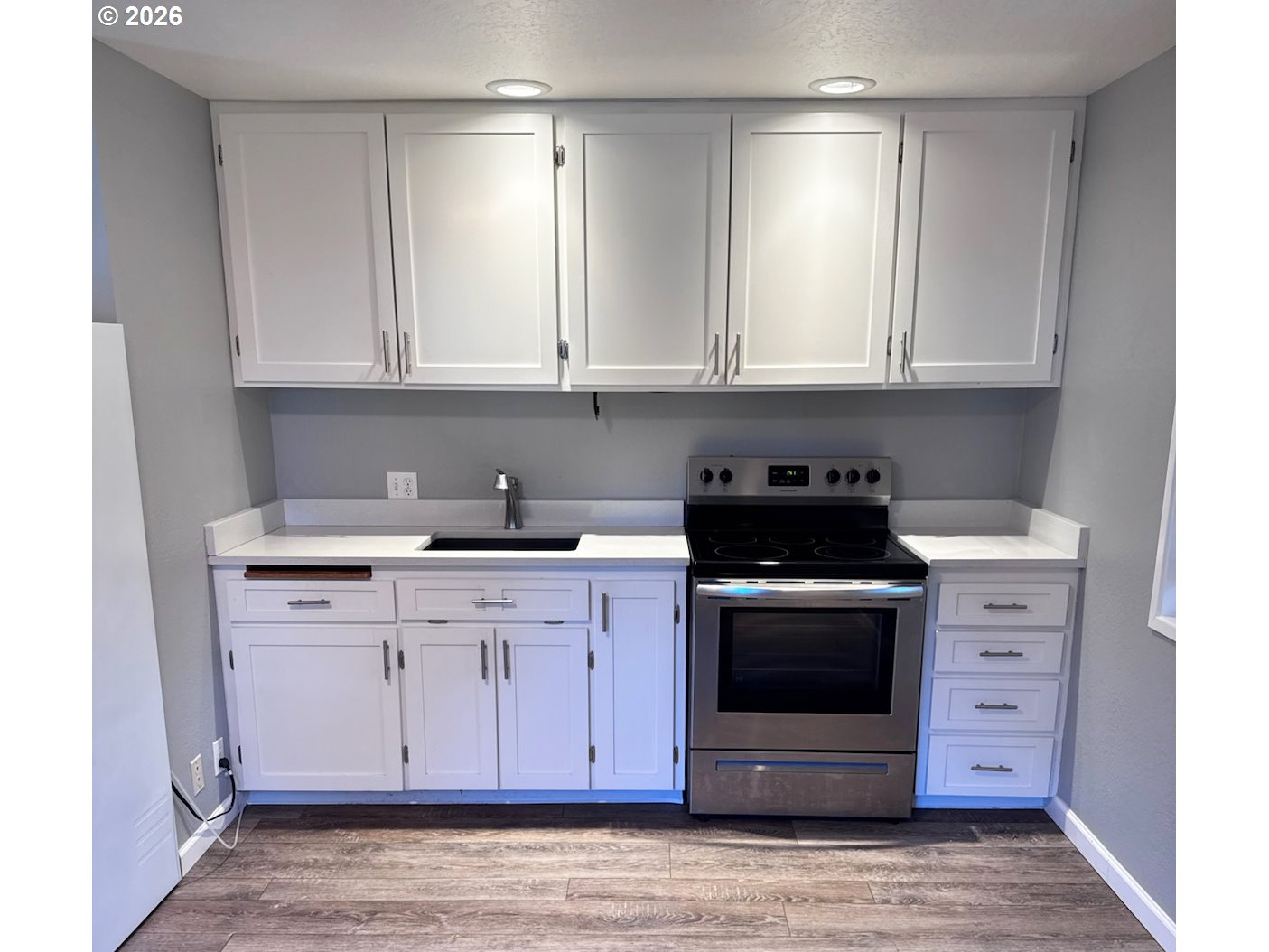 3085 Beach Loop Drive Southwest Bandon, OR 97411 - Photo 34 of 46 a kitchen with stainless steel appliances granite countertop a stove a sink and white cabinets