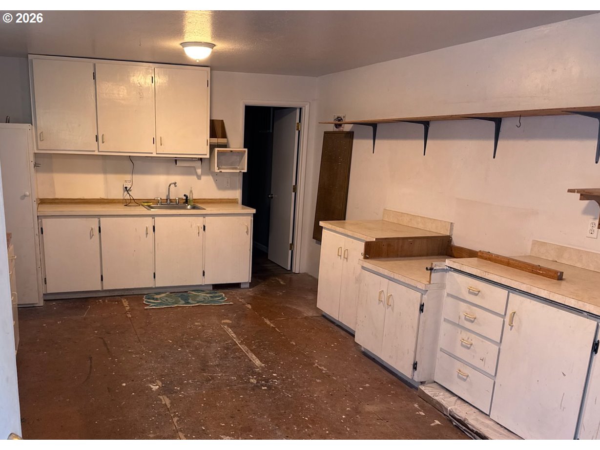 3085 Beach Loop Drive Southwest Bandon, OR 97411 - Photo 39 of 46 a kitchen with white cabinets and white appliances