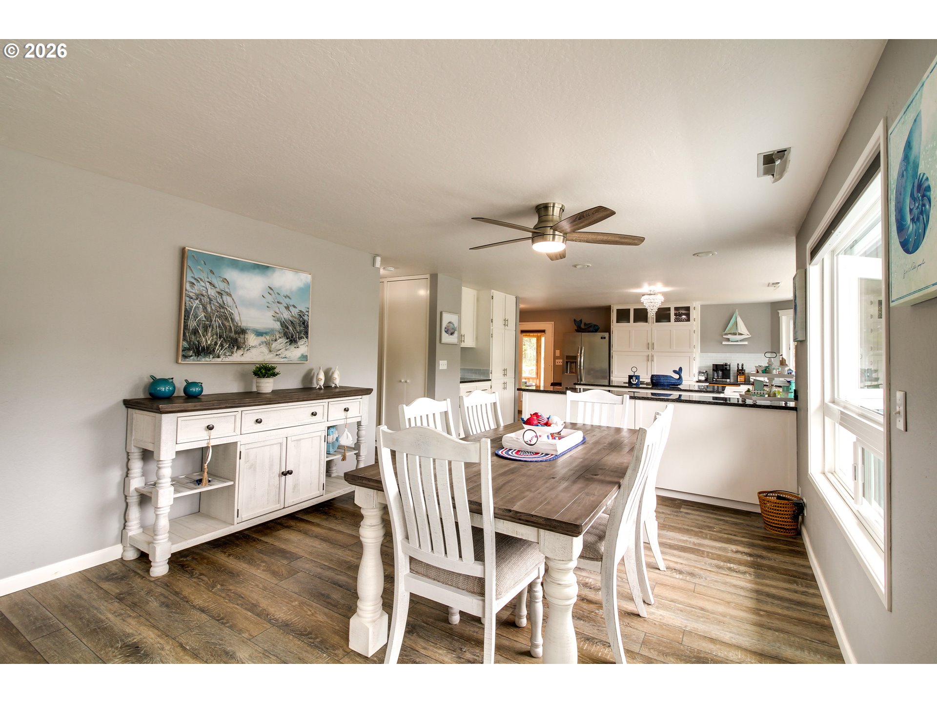 3085 Beach Loop Drive Southwest Bandon, OR 97411 - Photo 9 of 46 a dining hall with stainless steel appliances kitchen island granite countertop a dining table chairs and white cabinets
