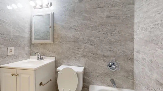 a bathroom with a sink a toilet and mirror