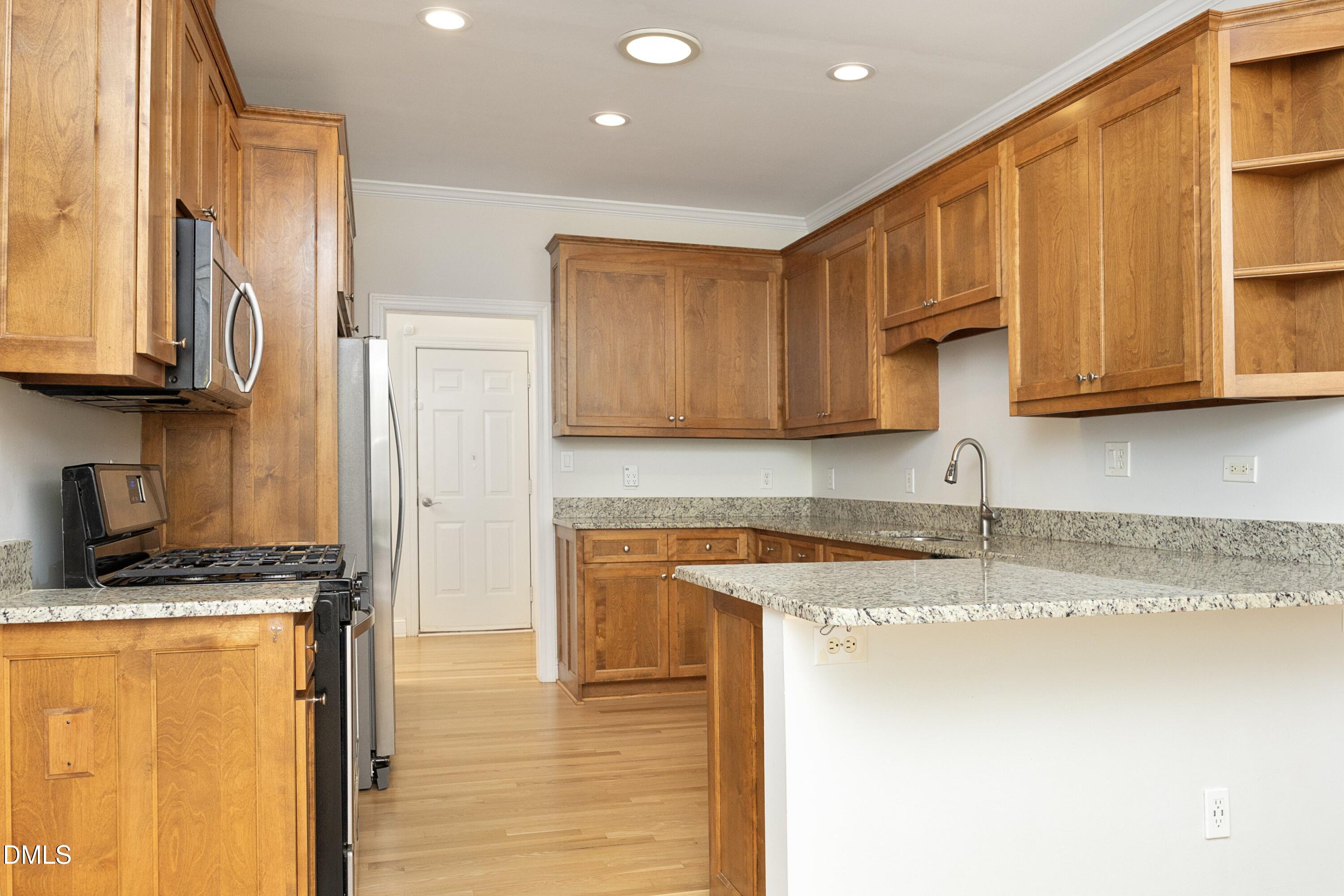 1427 Moosecreek Drive Raleigh, NC 27614 - Photo 16 of 48 a kitchen with stainless steel appliances granite countertop a sink a stove a refrigerator a microwave and cabinets
