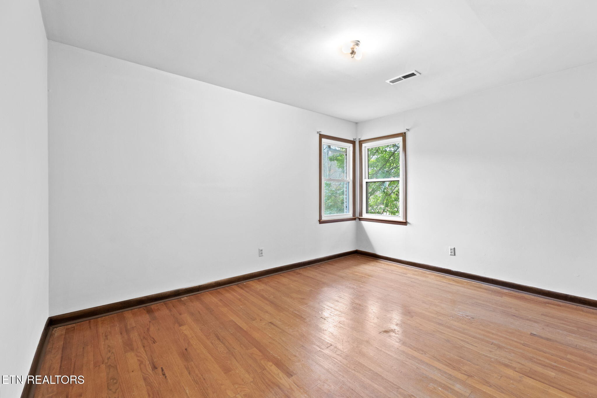 352 Walnut Valley Road Clinton, TN 37716 - Photo 13 of 36 an empty room with wooden floor and windows