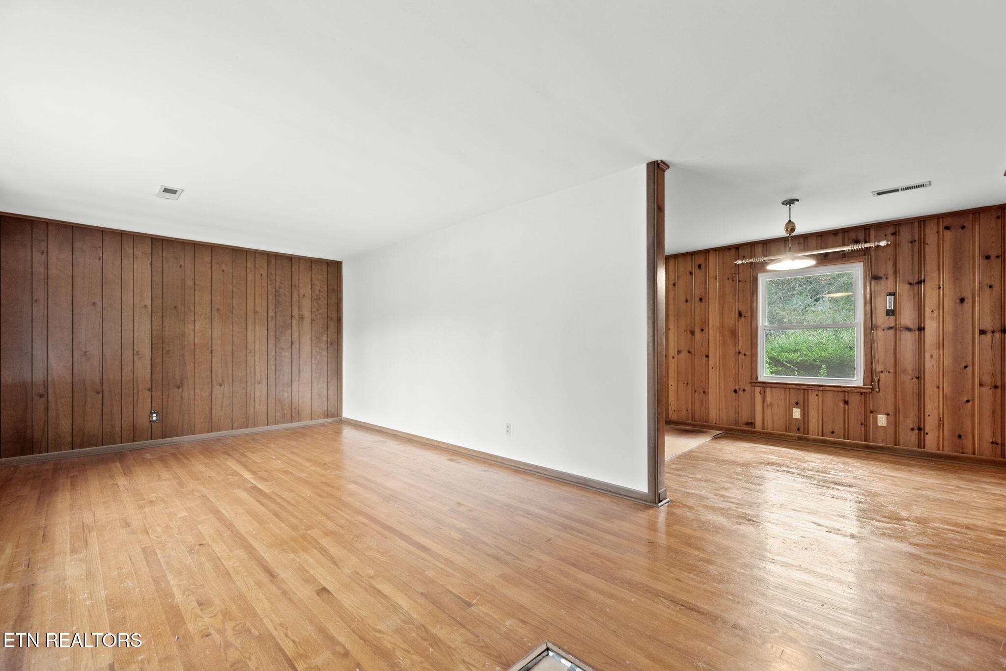 352 Walnut Valley Road Clinton, TN 37716 - Photo 4 of 36 a view of an empty room with wooden floor and a window