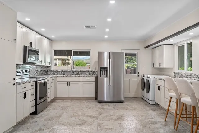 a spacious bathroom with a granite countertop sink mirror and shower