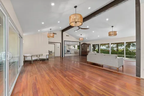 a living room with furniture kitchen and a large window