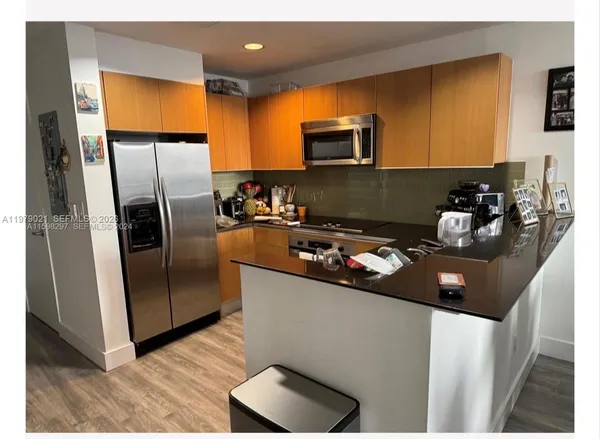 a kitchen with stainless steel appliances a refrigerator a sink a stove a microwave a counter top and cabinets