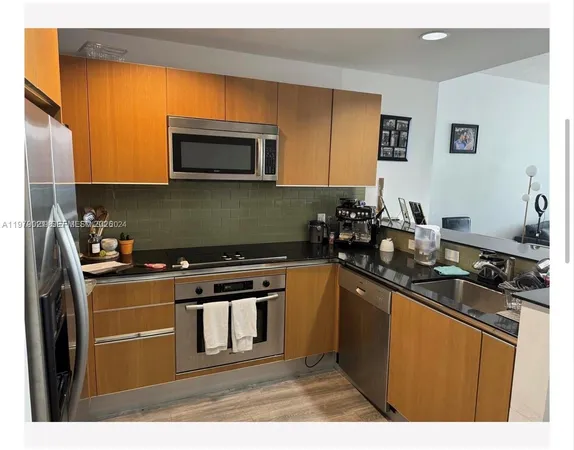 a kitchen with stainless steel appliances granite countertop a stove a sink and a microwave