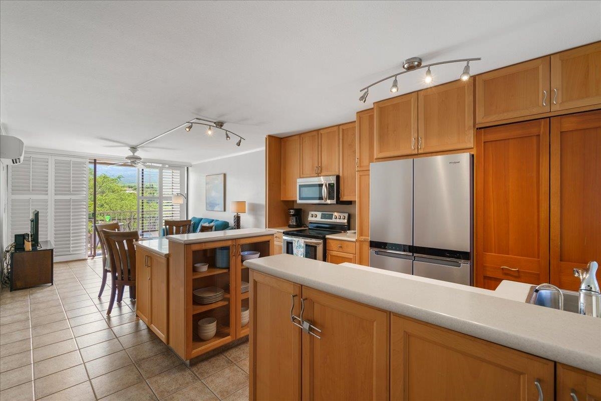 a kitchen with kitchen island granite countertop a sink counter top space appliances and cabinets