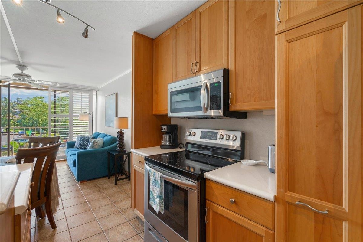 2219 South Kihei Road, Unit B414 Kihei, HI 96753 - Photo 18 of 42 a kitchen with a stove a sink and a microwave