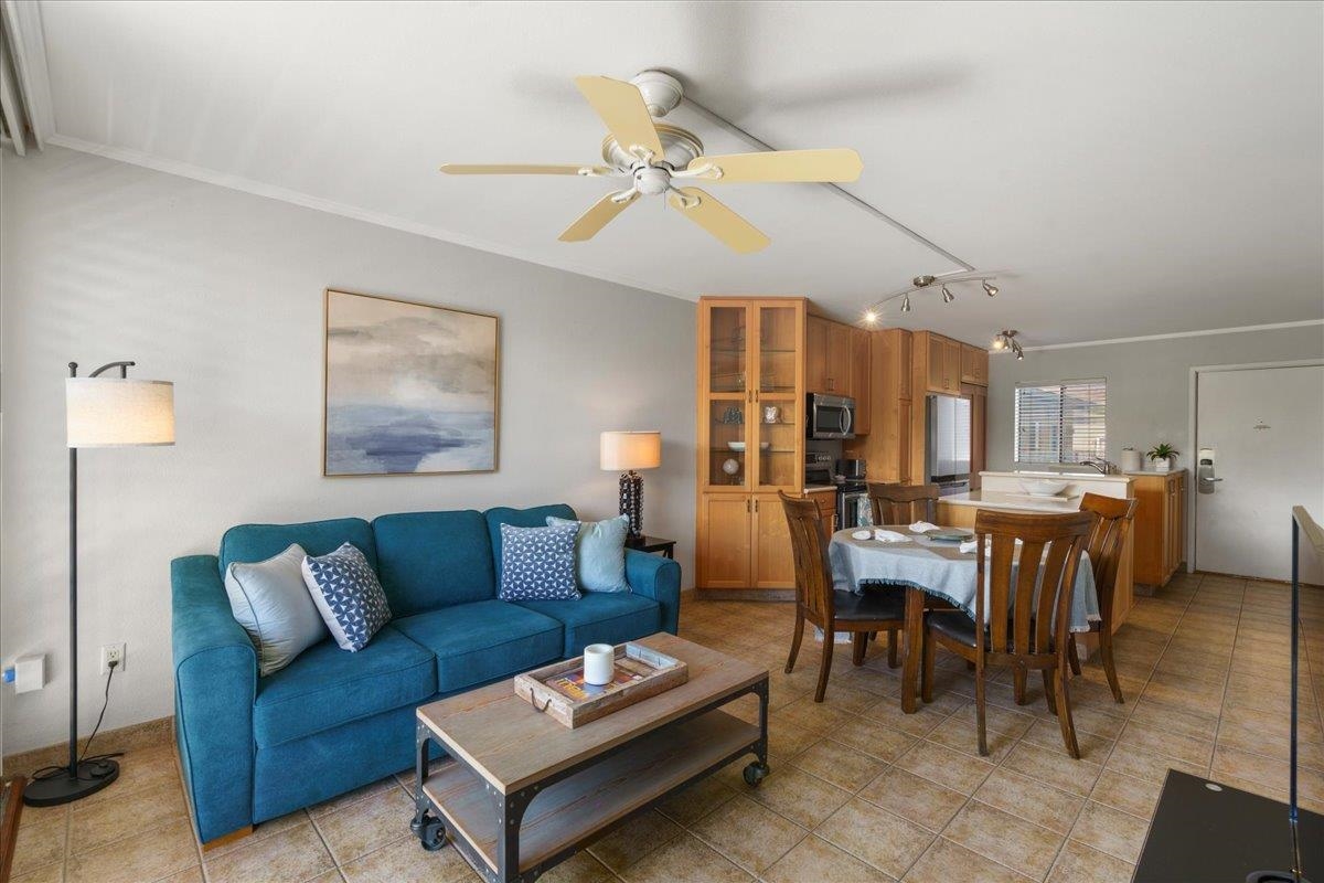 2219 South Kihei Road, Unit B414 Kihei, HI 96753 - Photo 9 of 42 a living room with furniture a chandelier and a dining table