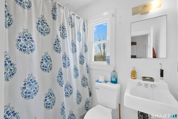 a living room with furniture a flat screen tv and a window