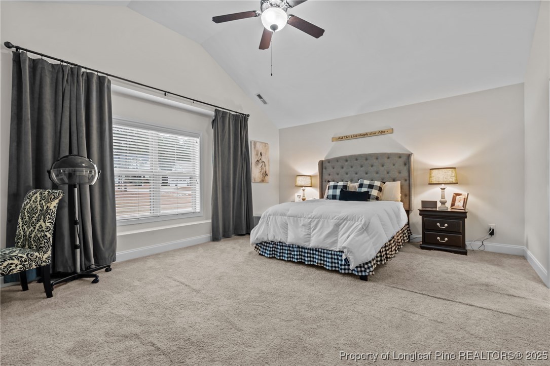 182 Valley Stream Road Spring Lake, NC 28390 - Photo 12 of 26 a spacious bedroom with a bed and a chandelier