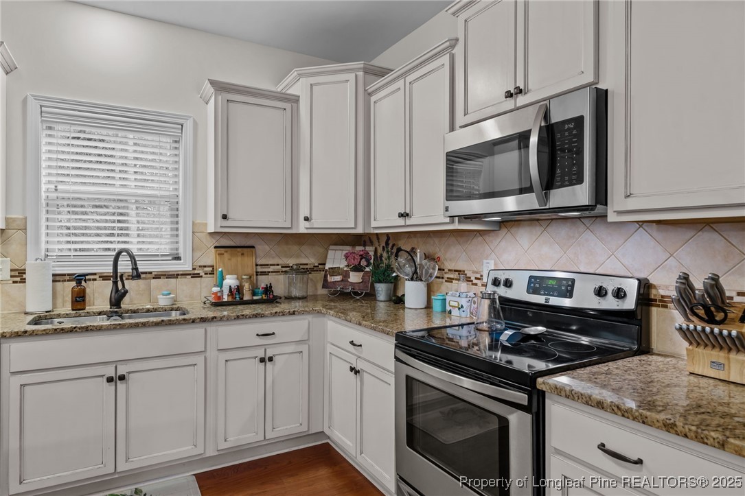 182 Valley Stream Road Spring Lake, NC 28390 - Photo 6 of 26 a kitchen with stainless steel appliances granite countertop grey cabinets a stove a sink and dishwasher