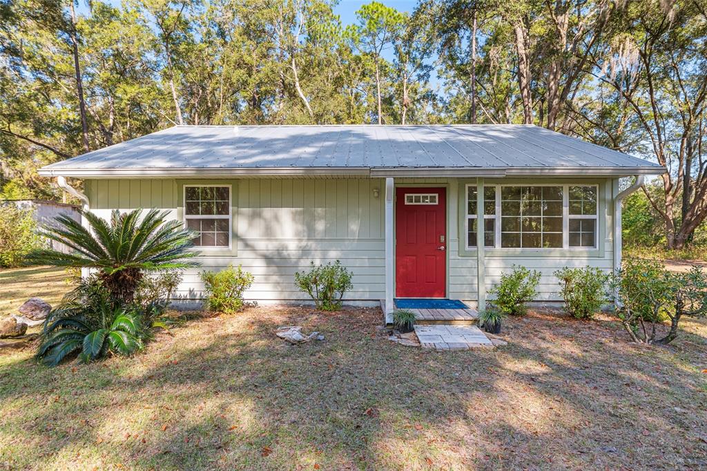18124 Southwest 75 Avenue Archer, FL 32618 - Photo 1 of 52 a front view of a house with garden