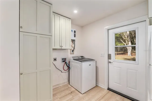 a room with stainless steel appliances a refrigerator and cabinets