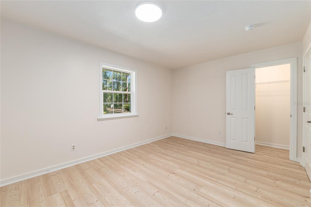 18124 Southwest 75 Avenue Archer, FL 32618 - Photo 18 of 52 wooden floor in an empty room with a window