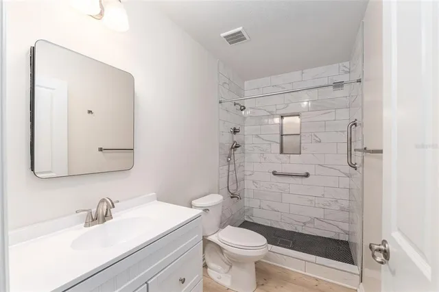 a bathroom with a sink a toilet and shower