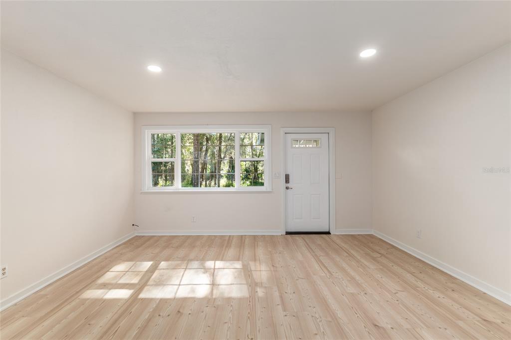 18124 Southwest 75 Avenue Archer, FL 32618 - Photo 9 of 52 an empty room with wooden floor and windows