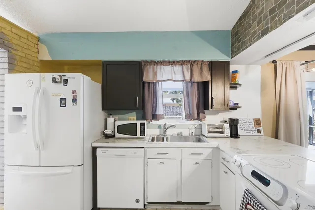 a kitchen with white cabinets and refrigerator
