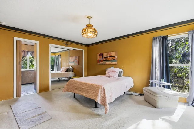 a bedroom with a bed and a large window