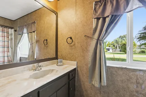 a bathroom with a granite countertop sink and a mirror