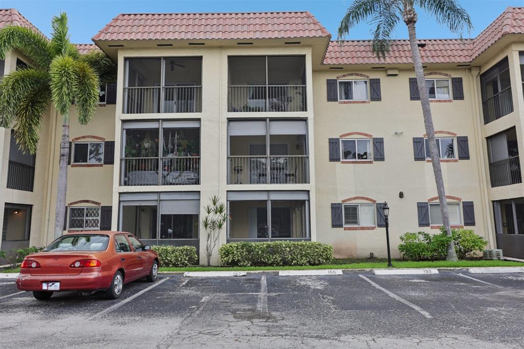 251 South Cypress Road, Unit 120 Pompano Beach, FL 33060 - Photo 2 of 42 a front view of a residential apartment building with a yard