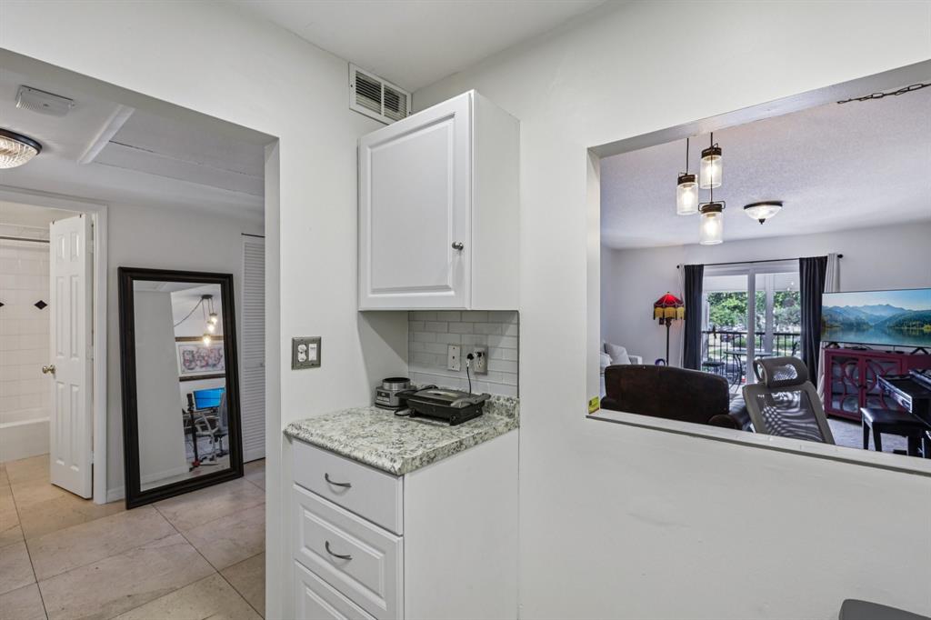 251 South Cypress Road, Unit 120 Pompano Beach, FL 33060 - Photo 5 of 42 a kitchen with granite countertop a stove and a refrigerator