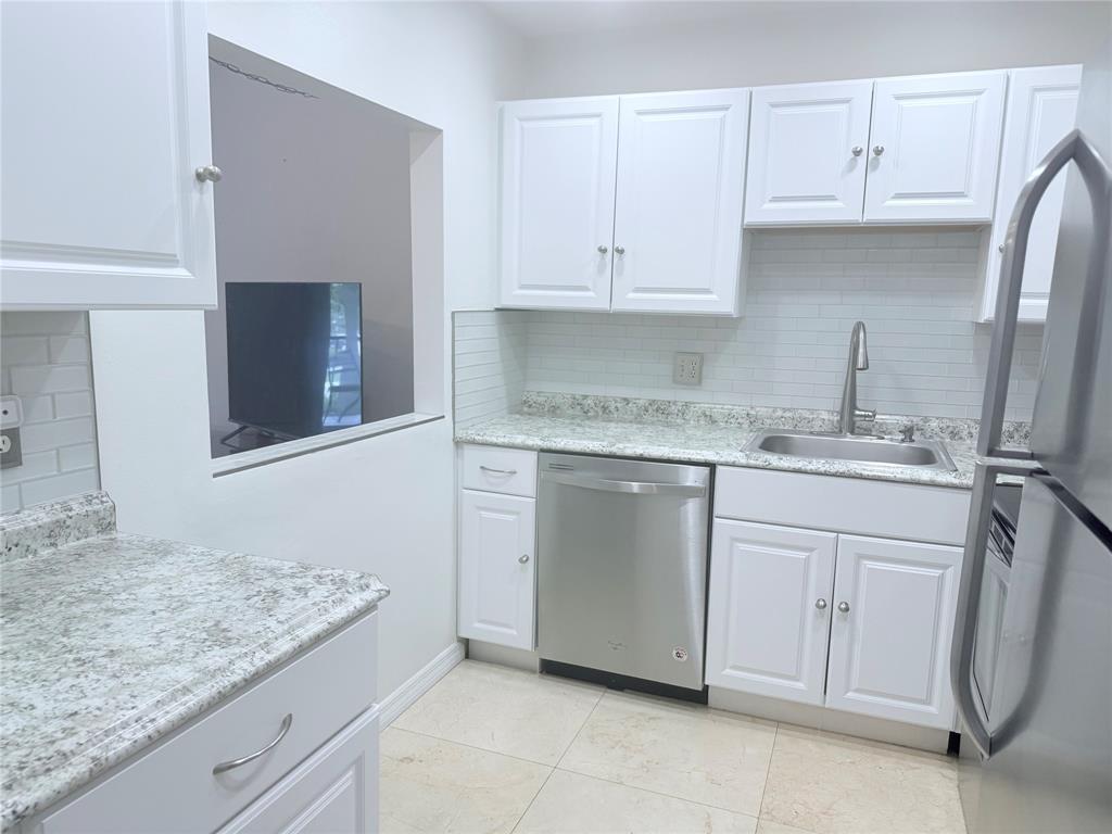 251 South Cypress Road, Unit 120 Pompano Beach, FL 33060 - Photo 10 of 42 a kitchen with white cabinets and sink