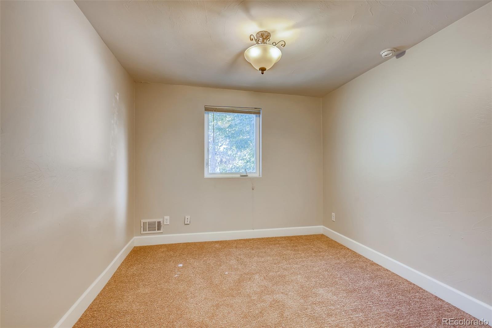 5535 Tejon Street Denver, CO 80221 - Photo 18 of 23 an empty room with a chandelier fan and windows